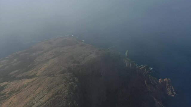 Vue a&eacute;rienne (drone) de la Tour de Turghui du Capo Rosso pr&egrave;s des calanques de Piana, dans les nuages, en Corse