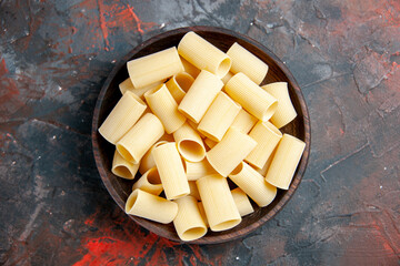 Close up view of uncooked pastas inside the pot on black background