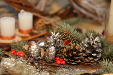 Beautiful silver pine cones on blurred white candles backdrop christmas decoration art, Happy new year background close up