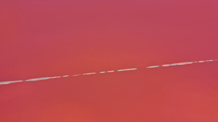 Aerial drone top down photo of a natural pink lake Kuyalnik in Odessa, Ukraine. Lake naturally turns pink due to salts and small crustacean Artemia in the water. This miracle is rare occurrence