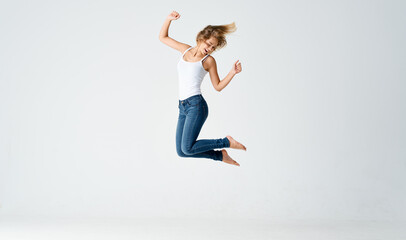 Fototapeta premium woman jumped up on a light background in full growth sport fitness