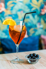photograph of an orange cocktail with citrus slices decorating the glass