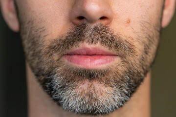 Obraz premium A young Caucasian man with brown and white facial hair with a serious look. Shallow depth of field.
