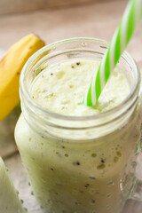 healthy green smoothie with spinach, celery and banana in glass jars