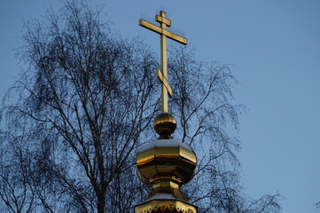 Russia: dome with a cross on the background of the autumn sky and trees
