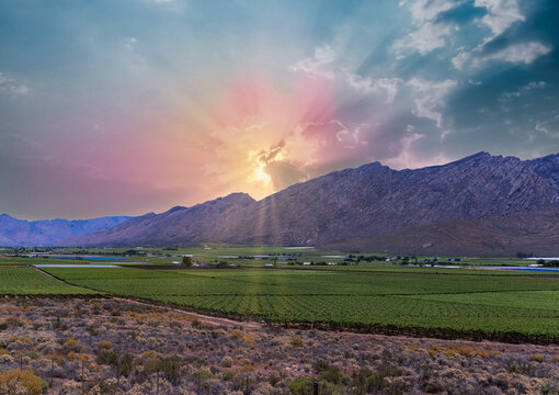 Hex River valley wine farms and mountains with sun rays behind the cloud in Western Cape South Africa