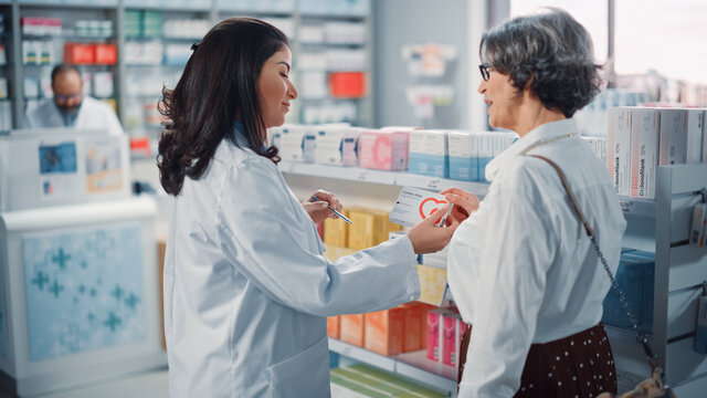 Pharmacy Drugstore: Senior Woman Chooses to Buy Medicine, Drugs, Vitamins. Professional, Helpful Pharmacist Advicing Customer Best Option. Modern Pharma Store Health Care Products