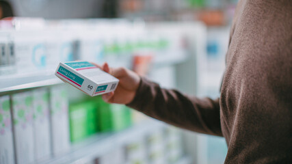 Pharmacy Drugstore: Close-up Shot of Handsome Young Man Browsing Shelves to Buy Medicine, Drugs,...