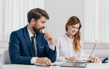 Business man and woman in shirt with laptop at the table in the office staff office
