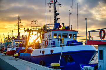 fishing boats in the harbor at sunset