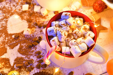 sweet food top view background for merry christmas or new year holiday decoration with night illumination - chocolate candies, tangerines, cookies, marshmallow and cocoa latte on white wood