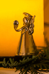 Silberner Weihnachtsengel vor brennender Kerze