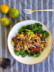 Italian style pasta bowl with avocados, spinach and tomatoes