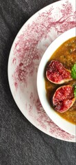 Figs and a carrots pupkin soup bowl with a traditional english old ceramic. A bit of mint on top the beatiful food creation. 