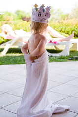 child standing with a crown on a head