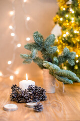 Burning candle on the table near to the Christmas tree. Zero waist christmas decoration. Handmade decoration