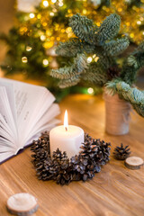 Burning candle on the table near to the Christmas tree. Zero waist christmas decoration. Handmade decoration