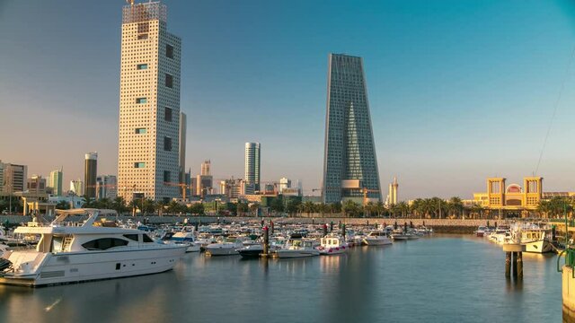 Yachts and boats at the Sharq Marina harbor morning timelapse after sunrise in Kuwait. Modern towers reflectied in the water. Kuwait City, Middle East.