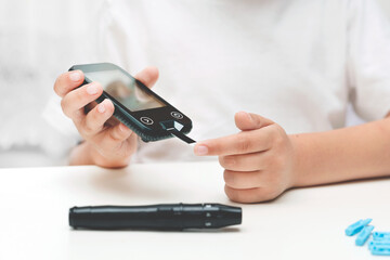 Young boy using glucometer, children diabetes