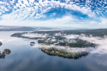 Deep Cove, Greater Vancouver, British Columbia, Canada. Beautiful view on the luxury homes in a modern city covered in fog. Colorful Sunny Morning Sky.