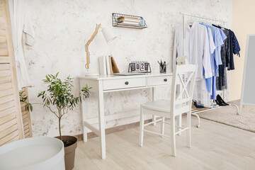 Interior of modern room with clothes rack and  comfortable workplace