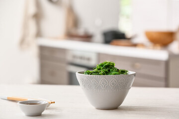 Bowl with tasty seaweed salad in kitchen