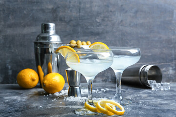 Glasses of tasty martini with lemon on grunge background