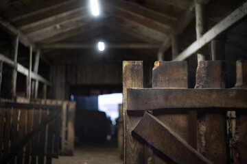 Fototapeta na wymiar open gate in a wooden dark farm barn