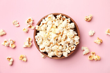 Fototapeta na wymiar Bowl of tasty popcorn on color background