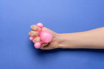 Hand with stress ball on color background