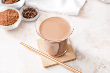 Glass of tasty chocolate milk on table