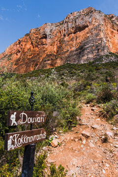 Kokkinovrachos rock in Leonidio and the wooden sign for the path directions. Rock climbing in Greece