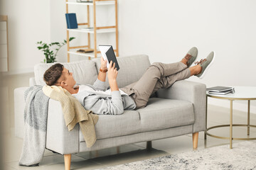 Teenage boy reading book at home