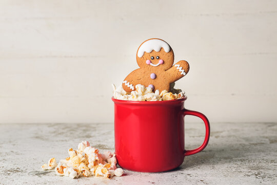 Cup with gingerbread cookie and popcorn on white background