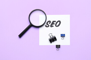 Paper sheet with abbreviation SEO and magnifier on color background