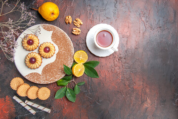 top view yummy little cookies with cup of tea on dark background sugar cake sweet biscuit