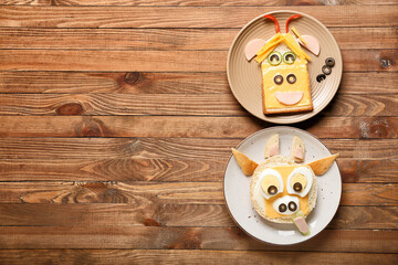Plates with tasty sandwiches in shape of bull on wooden background