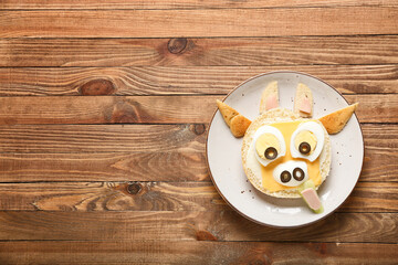 Plate with tasty sandwich in shape of bull on table