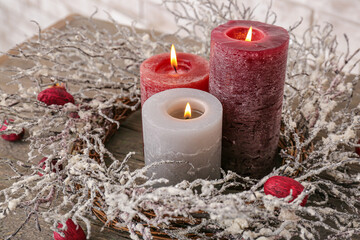 Beautiful aroma candles with Christmas decor on table