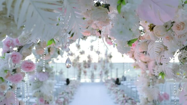 Decor for a wedding on the background of the sea. Arches of flowers at the beginning of the wedding path.