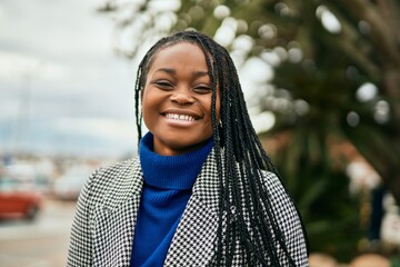 Young african american businesswoman smiling happy standing at the city.