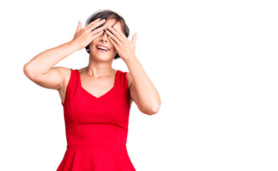 Beautiful young woman with short hair wearing casual style with sleeveless shirt covering eyes with hands smiling cheerful and funny. blind concept.