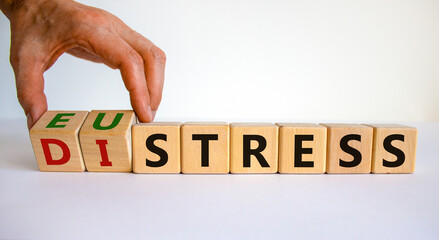 Distress or eustress symbol. Male hand turns cubes and changes the word 'distress' to 'eustress'....
