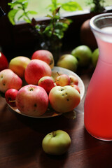 Tasty organic homemade pink juice from apples and garden berries on rustic wooden table of country house. Eco food in summer. 