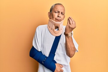 Handsome mature senior man wearing cervical collar and arm on sling doing italian gesture with hand...