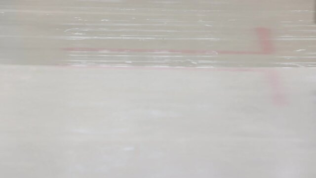 Resurfacing machine cleaning ice of hockey rink. Special machine for cleaning ice on an ice rink at work. Ice harvesters