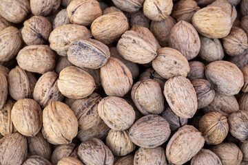 Beautiful, expensive walnuts in a container on the stall of an italian food market. Full frame close up of the nuts for wallpaper use.