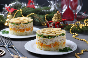 Puff salad with chicken, pickled mushrooms, potatoes and carrots on plates. New Year's composition. Horizontal format