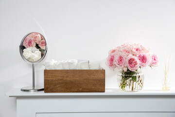 Rose White Pink O'hara in the round glass transparent vase is on the fireplace.