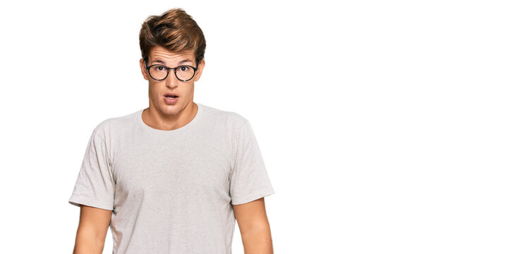 Handsome caucasian man wearing casual clothes and glasses afraid and shocked with surprise and amazed expression, fear and excited face.